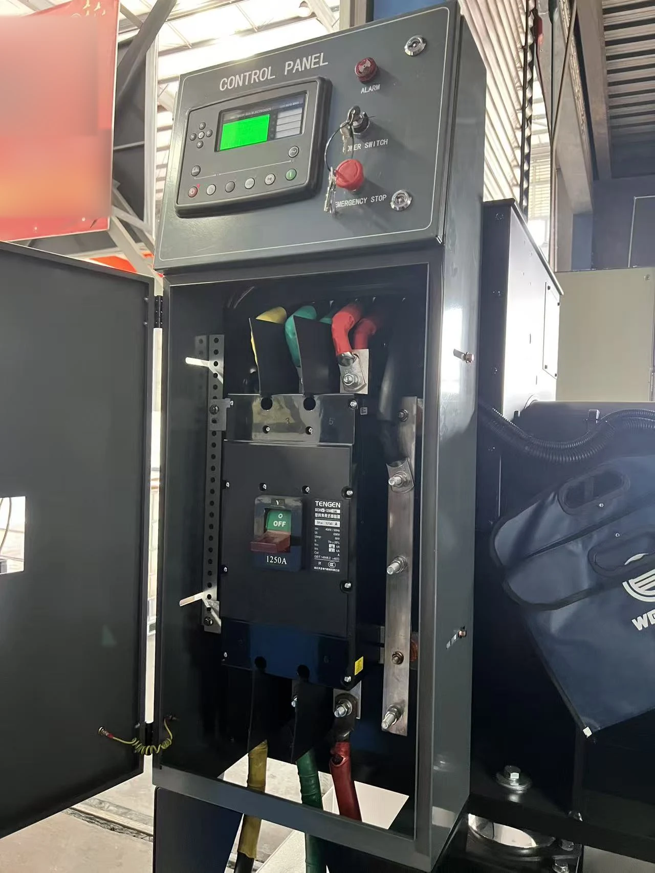 Open control cabinet showing the controller, emergency stop and 1250A output breaker