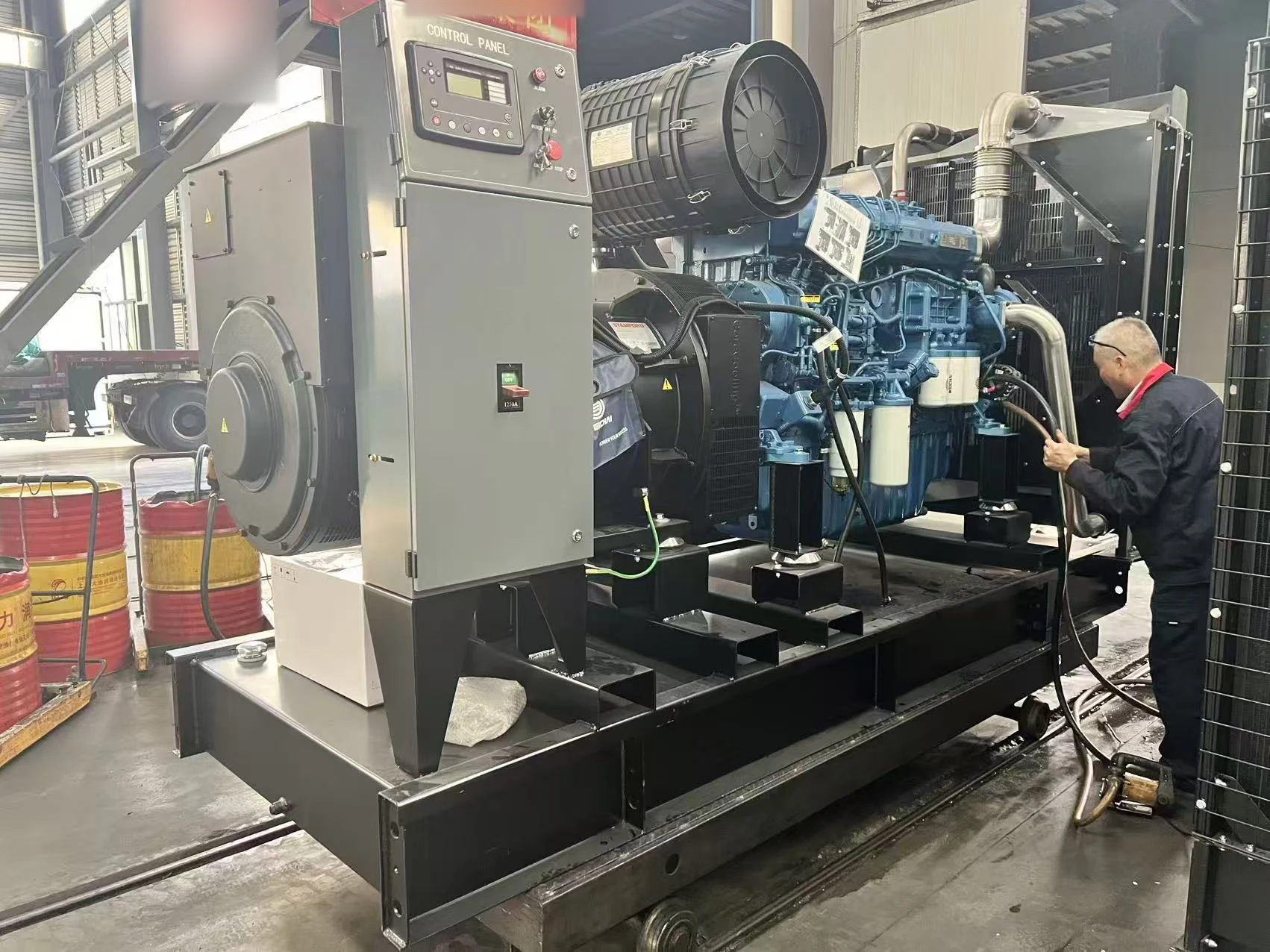 Technician checking components on a Weichai generator in the workshop