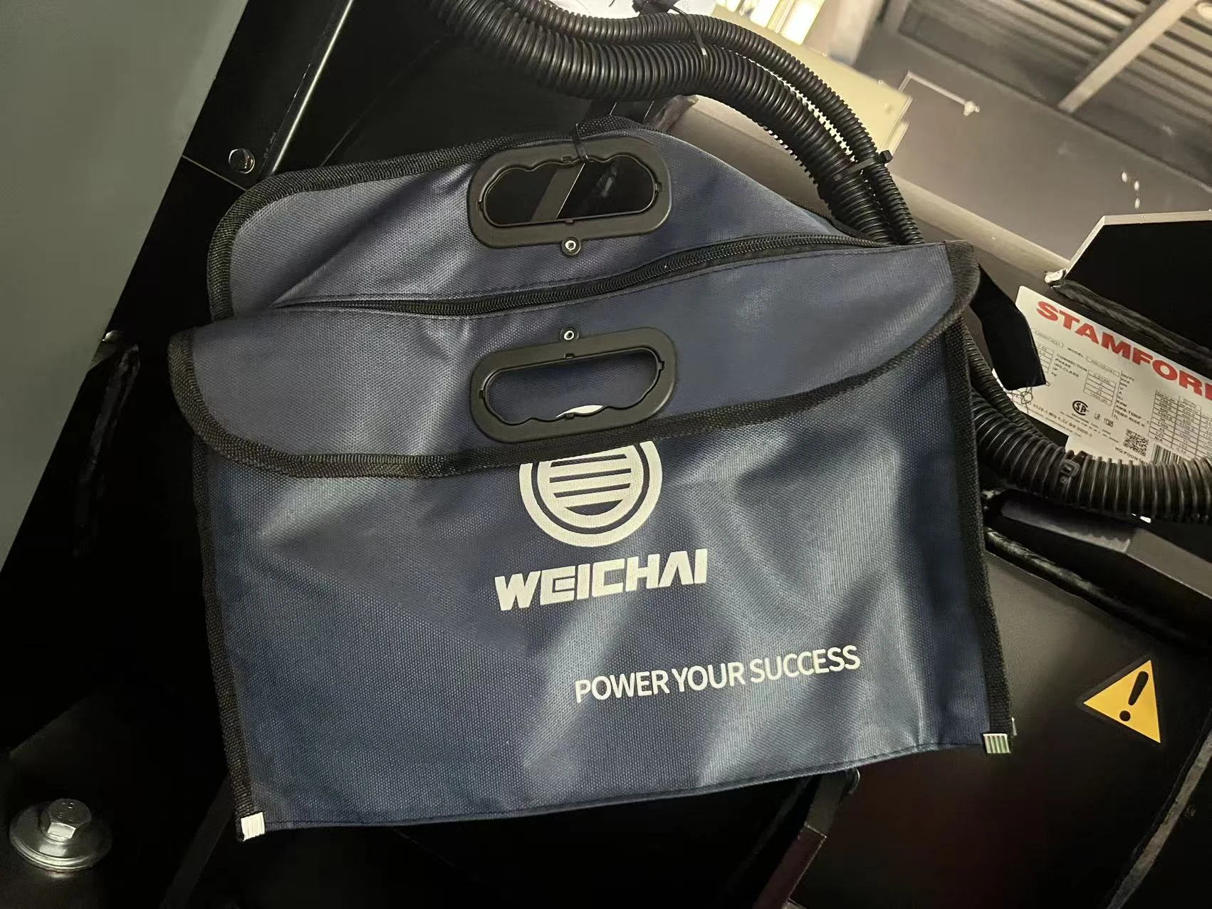 Weichai branded accessory bags beside the alternator label